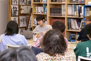 イベントの参加者に、看板に魅せられた経緯を説明するタキザワハルナさん（左奥）＝神戸市中央区元町通４
