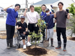 畑の一つを住民と交流する「観光農園」とし、記念のオリーブを植えた大橋賢一さん（右端）、久下剛人さん（左端）ら＝神戸市西区玉津町高津橋