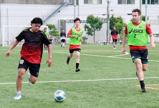 出身国の分け隔てなくサッカーで交流する参加者＝港島南球技場