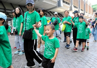 緑色のＴシャツを着て出発する参加者ら＝神戸市中央区浜辺通５