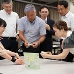 学生の考えたパッケージを手に取り、質問する担当者ら＝神戸芸術工科大学