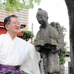 境内に設置された二宮金次郎像を見つめる城戸直和さん＝徳井神社