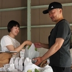 予約客に「ねおきの白コーン」を手渡す小林衣美さん（左）＝西区押部谷町西盛