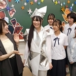 大阪・関西万博で実際に使われた衣装を試着する生徒ら＝神戸女子洋裁専門学校