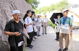碓井和貴さん（左端）の案内で、都賀川水難事故の現場を巡る参加者ら＝灘区内