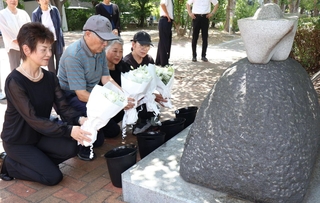 慰霊碑に花束をささげる参列者＝神戸市灘区神ノ木通４