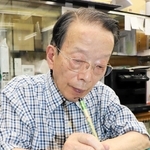祝い袋に名前をしたためる佐藤実さん＝神戸市兵庫区東山町１、佐藤紙店