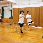 片脚を上げるヨガのポーズに挑戦する中学生ら＝原田中学校