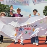 横断幕を手にリレーウオークの先頭を歩くがんの当事者や経験者ら＝みなとのもり公園