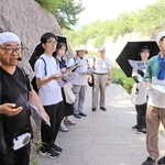 碓井和貴さん（左端）の案内で、都賀川水難事故の現場を巡る参加者ら＝灘区内
