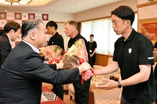 歓迎の花束を受け取る権田修一選手（右）ら＝神戸市役所