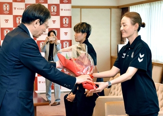 久元喜造市長から花束を受け取る宮本ともみ監督＝神戸市役所