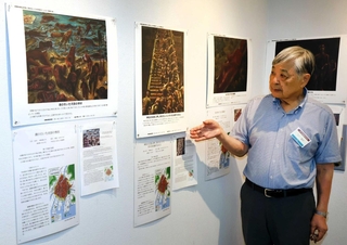 広島市立基町高校の生徒が被爆者から聞き取った体験をもとに描いた絵を紹介する、神戸市原爆被害者の会の立川重則会長＝こうべまちづくり会館
