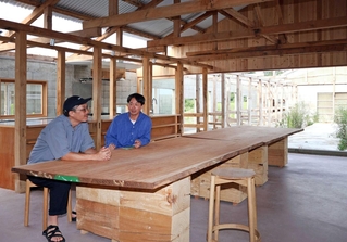 牛舎の構造を生かした開放的なワイナリー。宮本健司さん（右）は、地域住民らが集う拠点を目指している＝神戸市北区大沢町上大沢