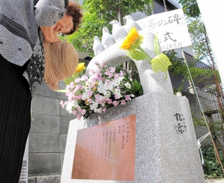 完成した憲法９条の碑に花を供え、平和を祈る除幕式の参加者＝神戸市灘区楠丘町６