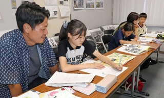金川佐智子さんの空襲体験などを基に新聞を手作りする子どもたち＝市立中央図書館