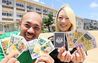 創立１５０年記念のトランプを制作した杉村宜紀さん（左）ら＝本山第一小学校