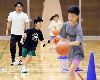 バスケットボールでドリブルの練習をする子どもたち＝王子スポーツセンター