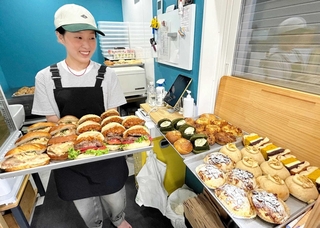 徹夜で仕上げたベーグルと川原未来さん。毎回１６種類用意する＝神戸市北区筑紫が丘４