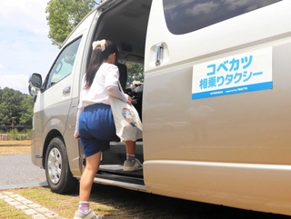 「コベカツ相乗りタクシー」を利用する女子生徒＝北区上津台７、上津公園