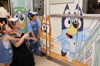 新装された「ブルーイ号」のイラストを見つめる親子＝市営地下鉄海岸線御崎公園駅