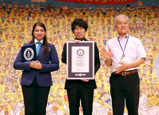 作品が「世界最多の間違い数」としてギネス世界記録に認定された山崎秀昭さん（中央）＝兵庫区役所