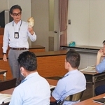 ツキノワグマの頭蓋骨を署員に示す岡居宏顕さん＝有馬署