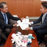 神戸キワニスクラブの秀平徹晃会長（右）からキワニスドールを受け取る黒田良祐病院長＝神戸大医学部付属病院