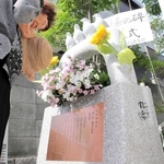 完成した憲法９条の碑に花を供え、平和を祈る除幕式の参加者＝神戸市灘区楠丘町６