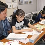 金川佐智子さんの空襲体験などを基に新聞を手作りする子どもたち＝市立中央図書館