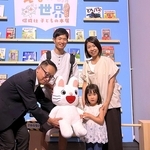 ５万人目の入場となり、記念品を受け取る横山莉子ちゃん（前列右）＝神戸ファッション美術館