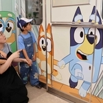 新装された「ブルーイ号」のイラストを見つめる親子＝市営地下鉄海岸線御崎公園駅