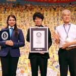 作品が「世界最多の間違い数」としてギネス世界記録に認定された山崎秀昭さん（中央）＝兵庫区役所