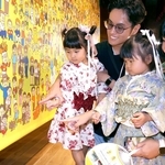 応募した写真が使われたイラストを見つけ、喜ぶ家族＝兵庫区役所