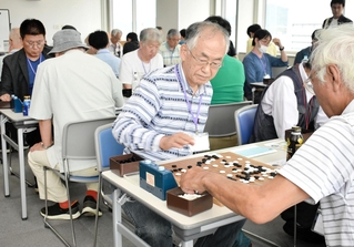 盤上の熱戦を繰り広げる出場者たち＝神戸新聞本社