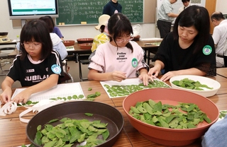 エノキの葉を数え、紙に貼っていく参加者＝神戸市立森林植物園
