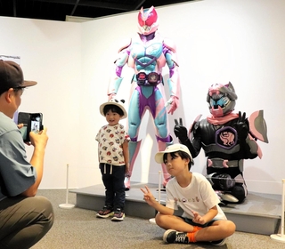 等身大の仮面ライダーと写真を撮る子どもたち＝神戸海洋博物館