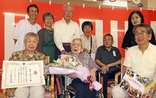 親族に囲まれ、神戸市内の最高齢者として祝福を受ける竹中志す子さん（前列中央）＝神戸市垂水区清水が丘２
