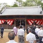 屋根瓦をふき替えた拝殿の前で竣工式を執り行う地元住民ら＝西区岩岡町岩岡