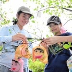 「ひかりの実」を木の枝にくくりつけていく六甲山小学校の児童ら＝灘区六甲山町、ＲＯＫＫＯ森の音ミュージアム