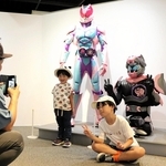 等身大の仮面ライダーと写真を撮る子どもたち＝神戸海洋博物館