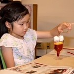 モクテルに乗った綿菓子を溶かして楽しむ子ども＝神戸市東灘区岡本、甲南大学岡本キャンパス