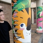 身長計アートを紹介する田村秀和さん。天王寺動物園の入り口の柱にあしらわれている＝大阪市天王寺区（撮影・高田康夫）