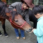 長年、牧場を支えてきた動物たちに感謝の餌やりをする子ども＝六甲山牧場