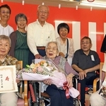 親族に囲まれ、神戸市内の最高齢者として祝福を受ける竹中志す子さん（前列中央）＝神戸市垂水区清水が丘２