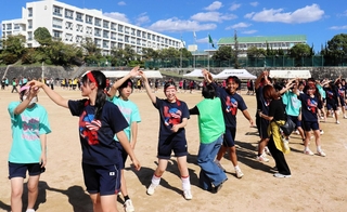 伝統のフォークダンス。笑顔でステップを踏む生徒や保護者ら＝伊川谷高校