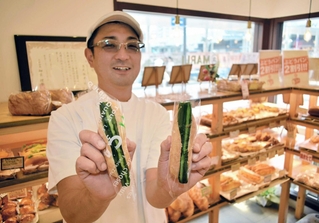 名物の「漬物ドック」（左）と「やみつきドック」を手にする末武達三さん＝神戸市垂水区神田町