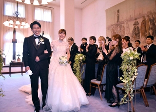 参列者から祝福を受ける清水崇央さん（左）と妻みなみさん＝兵庫県公館