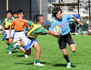 初めて開かれたタグラグビーの「平尾誠二杯」でトライを狙う子ども＝神戸市東灘区御影浜町