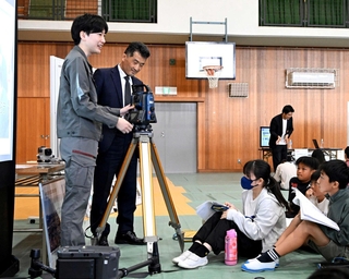 測量士の仕事を学ぶ児童ら＝舞子小学校